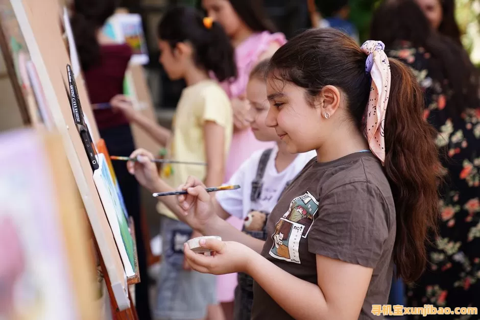 Group of children engaged in outdoor painting activities, fostering creativity and teamwork.