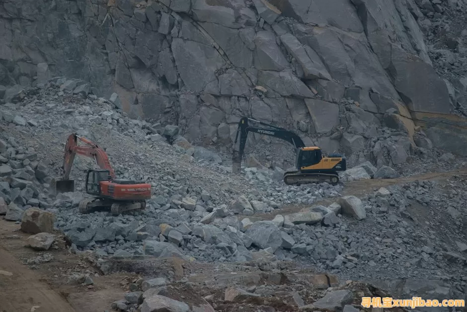 Dynamic construction site featuring excavators working on rocky terrain.