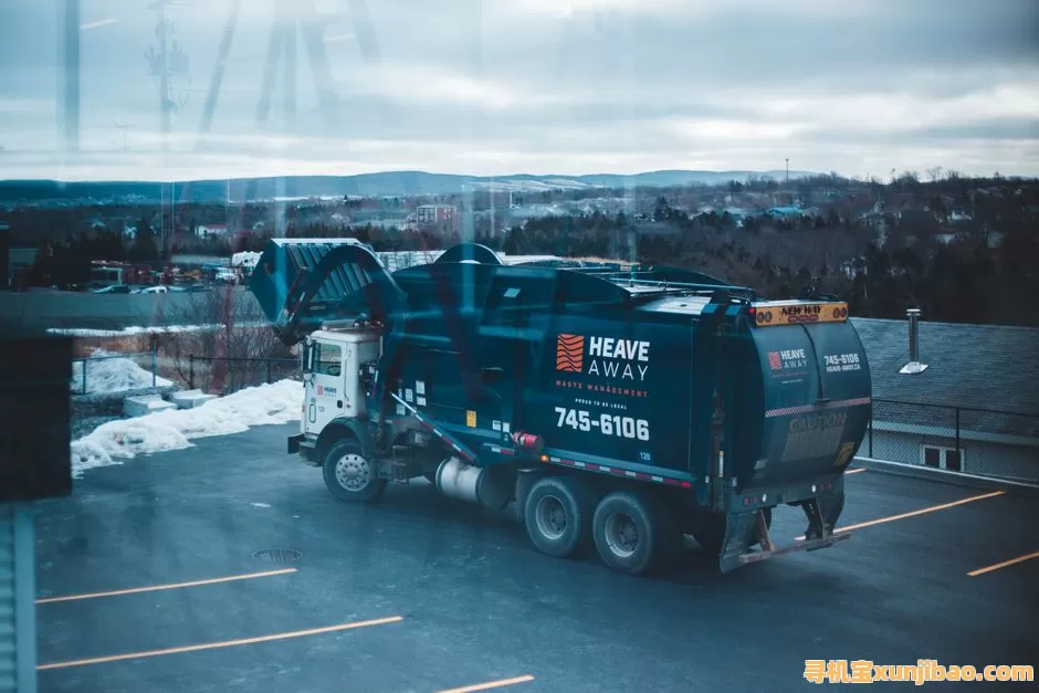 A waste management truck parked in a snowy lot, showcasing logistics in winter.